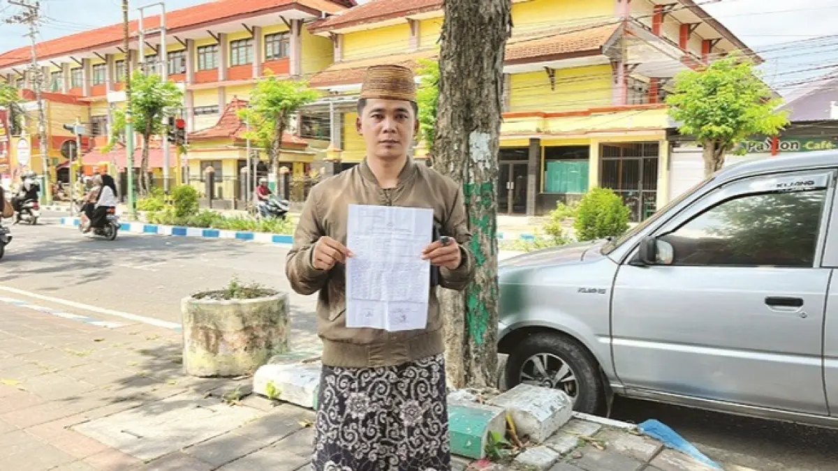 CARI KEADILAN: Korban Mat Bahri menunjukkan laporan polisi kasus dugaan penipuan, Selasa (21/4). (MOH. IQBAL AFGANI/JPRM)