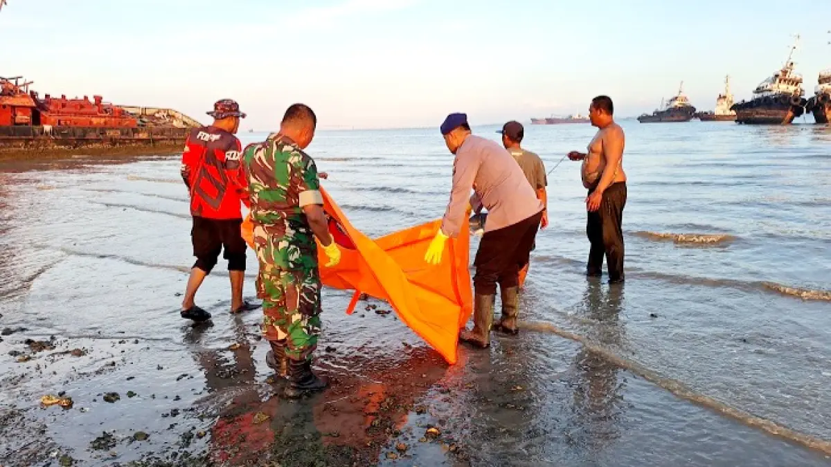 MENGGEGERKAN: Aparat dan warga mengevakuasi mayat berjenis kelamin perempuan di pesisir pantai, Selasa (5/5). (SATPOLAIRUD POLRES BANGKALAN UNTUK JPRM)