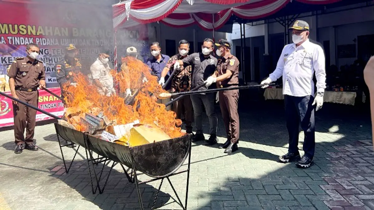 DIBAKAR: Kajari Sampang Mochamad Iqbal bersama Bupati Slamet Junaidi dan perwakilan forkopimda membakar barang bukti di halaman kantor kejari Kamis (7/5). (UBAIDILLAHIR RA’IE/JPRM)