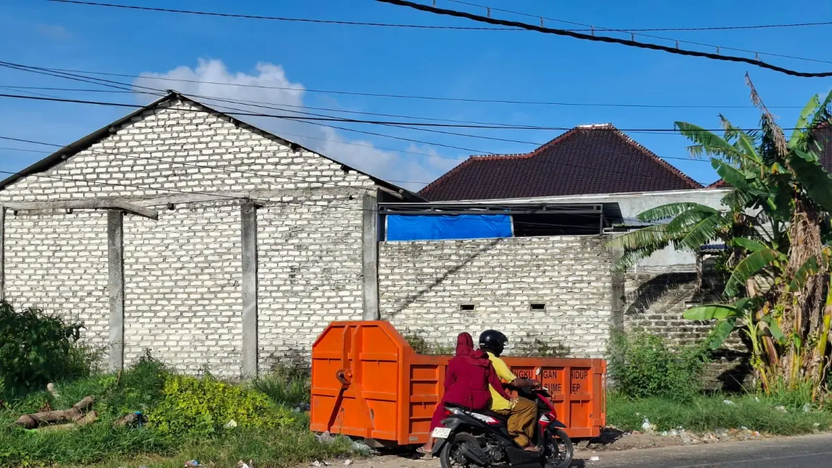 LANDAI: Pengendara melintas di depan kontainer sampah milik DLH di Jalan Jokotole, Gedungan, Batuan, Sumenep, Minggu (10/5).