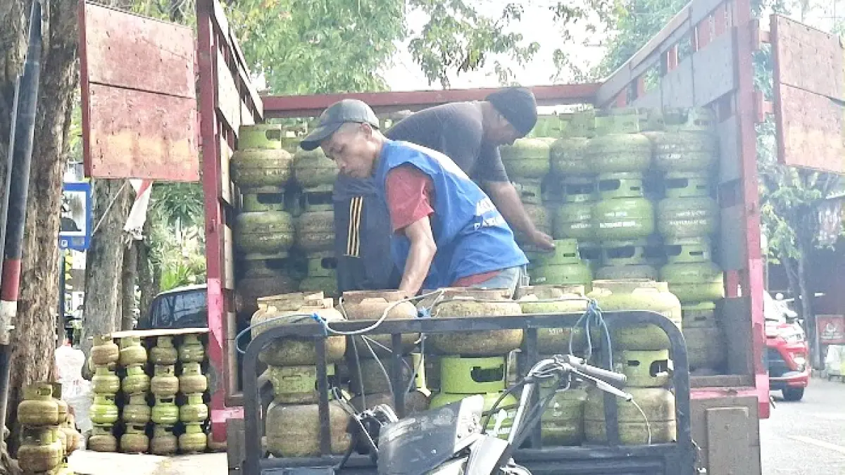 BEKERJA: Seorang pekerja menurunkan tabung elpiji melon dari truk pengangkut di Jalan Trunojoyo, Desa Kolor, Kecamatan Kota Sumenep, Senin (11/5). (MOH. LATIF/JPRM)