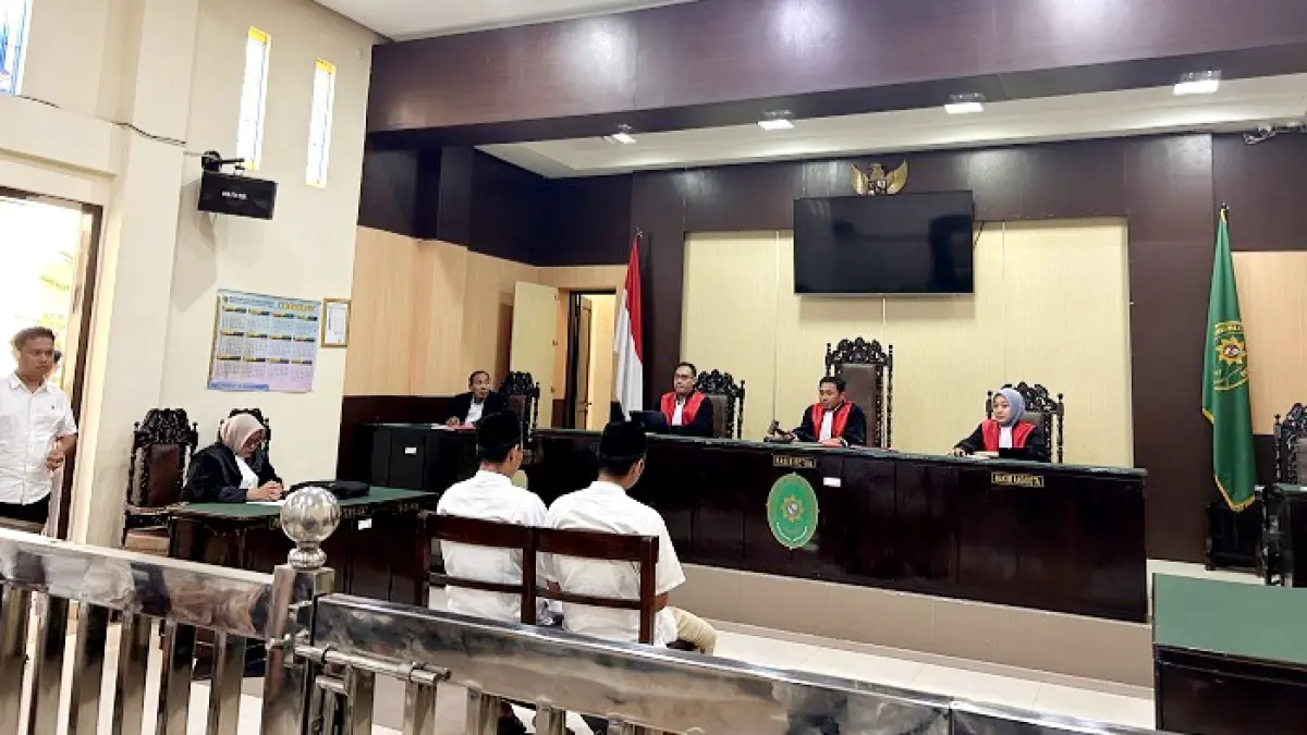 DIADILI: Dua terdakwa penganiaya guru tugas mengikuti sidang di Pengadilan Negeri Sampang Senin (11/5). (UBAIDILLAHIR RA’IE/JPRM)