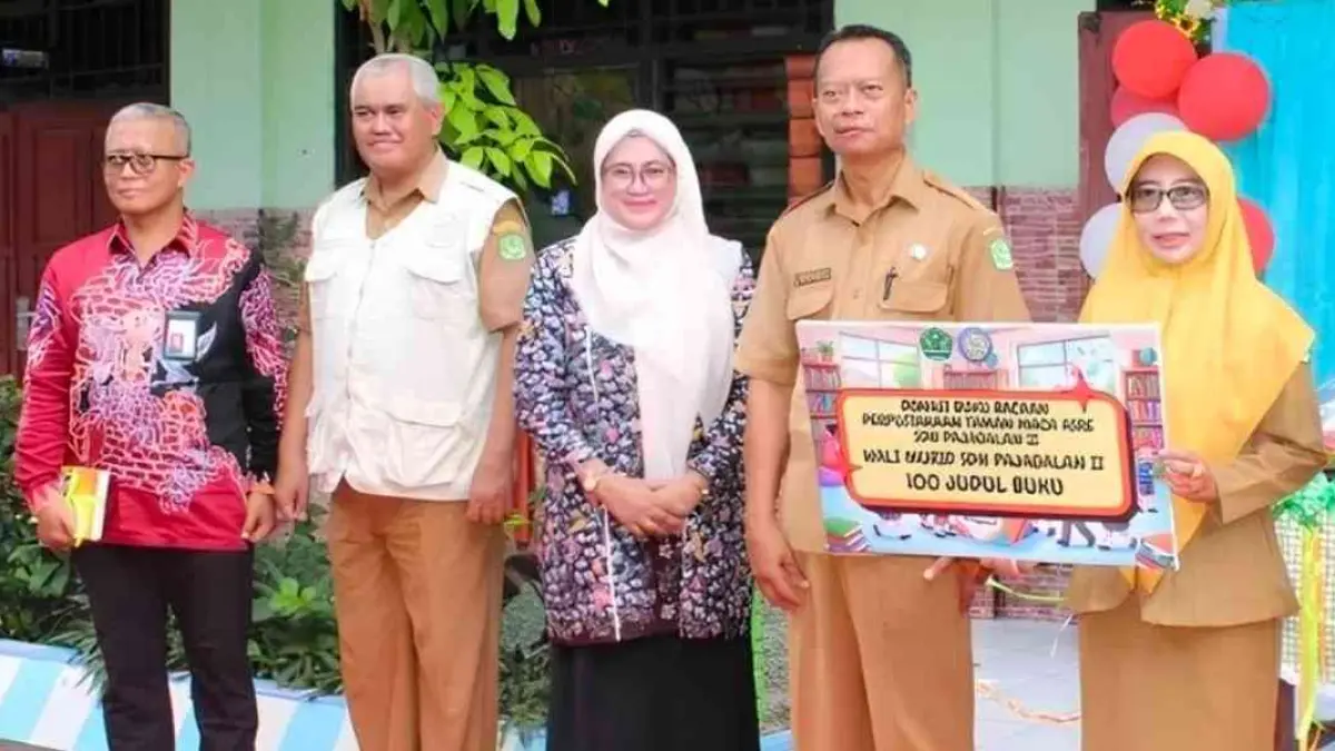 MELAYANI: Direktur Utama PT BPRS Bhakti Sumekar (Perseroda) Hairil Fajar (paling kiri) saat menyalurkan bantuan ke SDN Pajagalan 2, Sumenep.