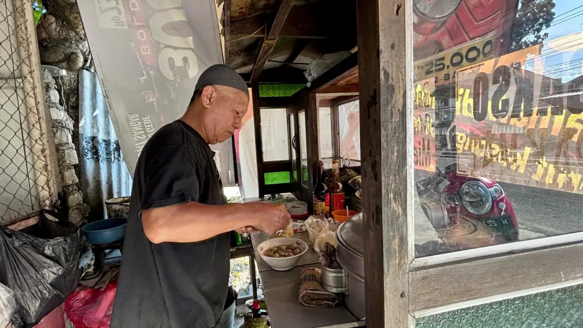 RAMAH: Pak Mat menyajikan pesanan bakso kepada pelanggan, Jumat (15/5).
