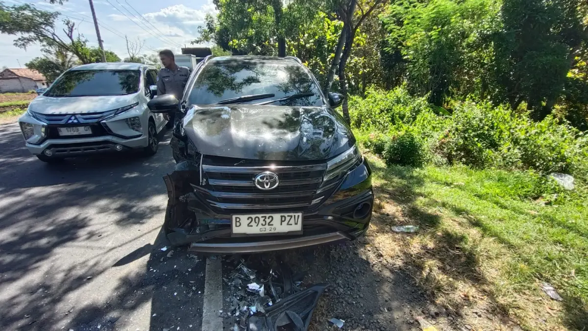 RUSAK: Warga berada di sekitar kendaraan Toyota Rush yang terlibat laka lantas di Jalan Raya Torjun, Kecamatan Torjun, Sampang, Kamis (14/5).