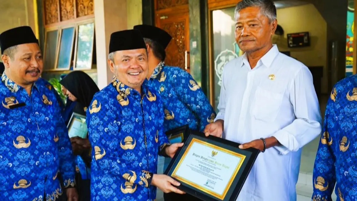 APRESIASI: Wabup Bangkalan Moch. Fauzan Ja’far menyerahkan piagam penghargaan kepada ASN yang memasuki purnatugas usai pelaksanaan apel peringatan Harkitnas. (PROKOPIM UNTUK JPRM)