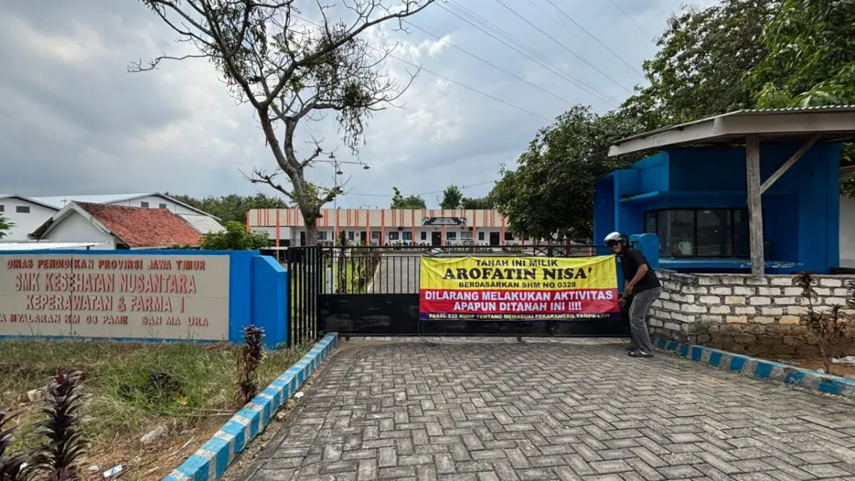 BERSENGKETA: Seorang warga melihat kondisi SMK Kesehatan Nusantara yang tersegel, Senin (18/5).