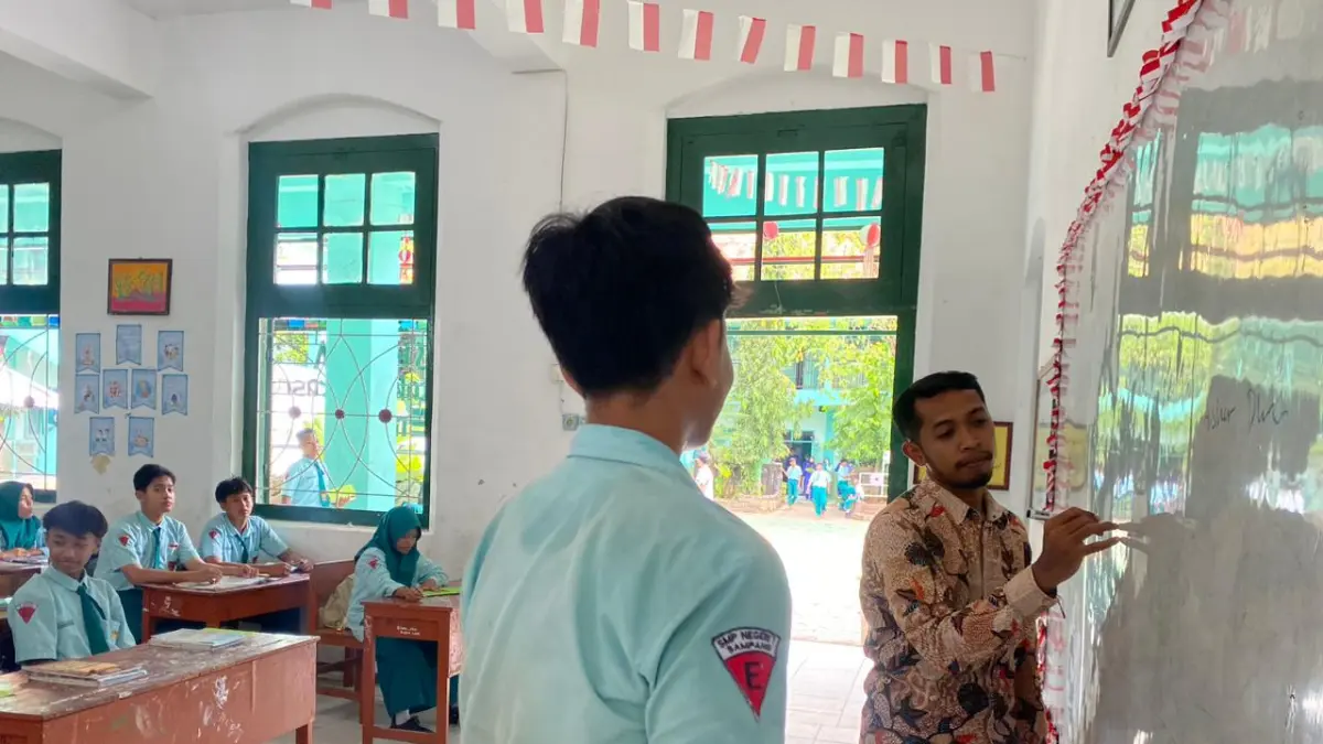 PENGABDIAN: Abdul Jalil guru SMPN 1 Sampang mengajar di salah satu kelas, Kamis (21/5).