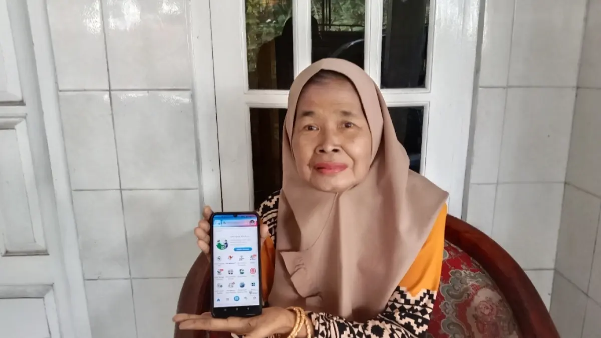 TERBUKTI: Peserta JKN asal Kabupaten Sumenep, Maryamah menunjukkan aplikasi kesehatan miliknya.