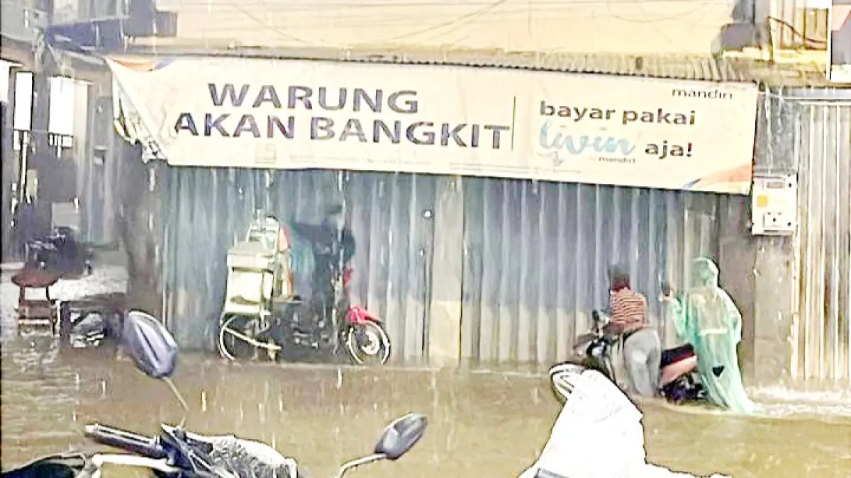 TERDAMPAK BANJIR: Seorang pengendara di Jalan Raya Telang, Kamal, Bangkalan, menerobos genangan air, Jumat (22/5) malam. (AMRILLAH UNTUK JPRM)