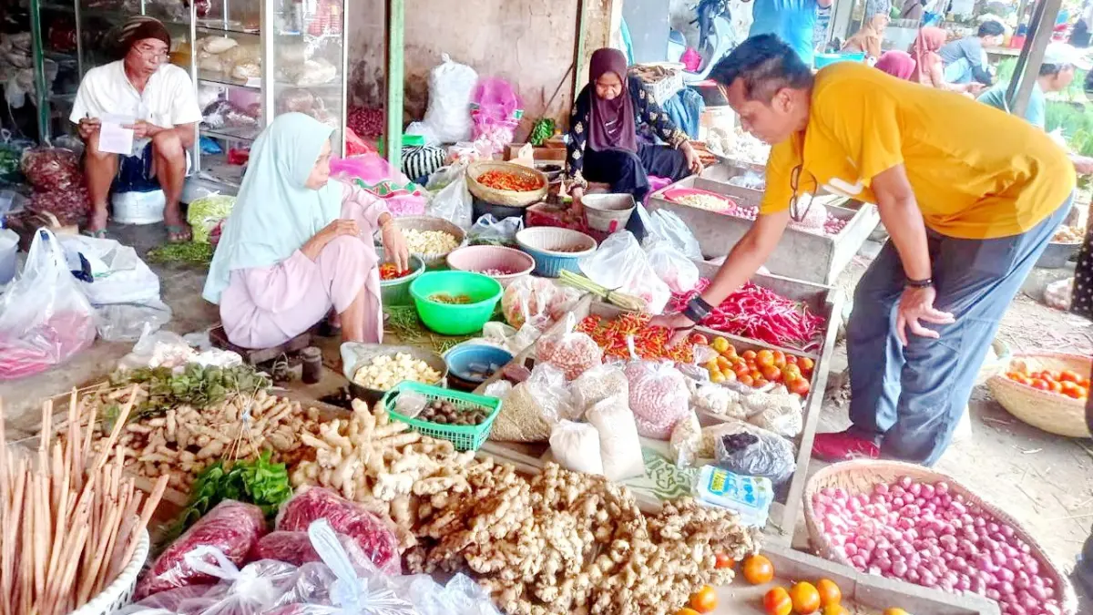 TURUN LANGSUNG: Sekretaris TPID Sumenep Dadang Dedi Iskandar (kaus kuning) saat melakukan pengecekan komoditas pangan di Pasar Anom pada Jumat (22/5). (TEMMY UNTUK JPRM)