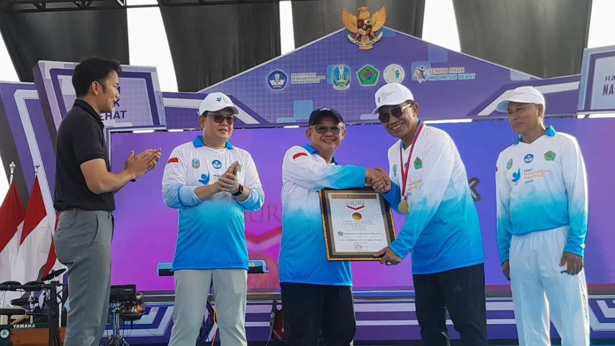 PRESTASI: Mendikdasmen Prof Dr Abdul Mu’ti menyerahkan piagam rekor Muri Senam Anak Indonesia Hebat oleh pelajar terbanyak di Indonesia kepada Bupati Pamekasan KH Kholilurrahman, Minggu (24/5).