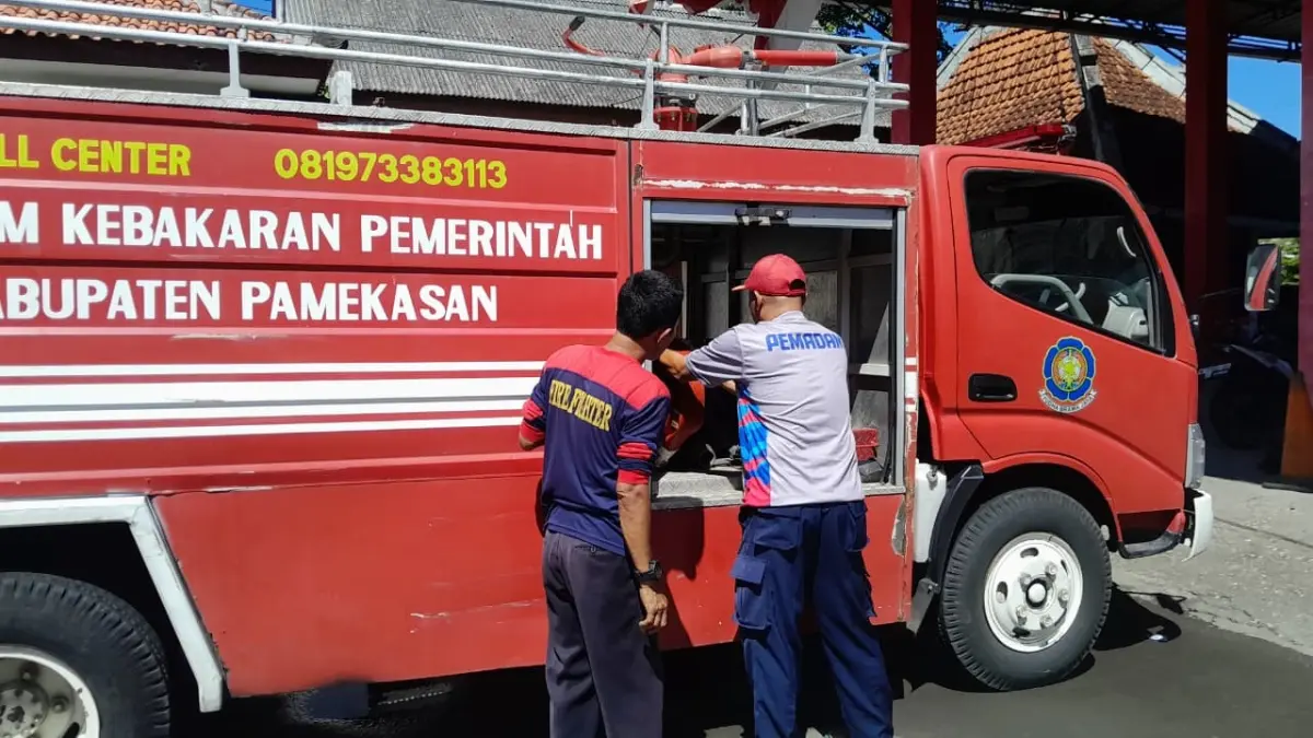 SIAGA: Petugas Damkar Pamekasan sedang mengecek kondisi alat pemadam, Minggu (24/5).