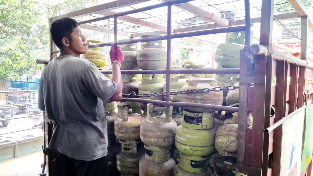 STOK AMAN: Sejumlah karyawan menurunkan tabung LPG 3 kg di salah satu agen di Jalan Jokotole, Pamekasan, Sabtu (23/5).