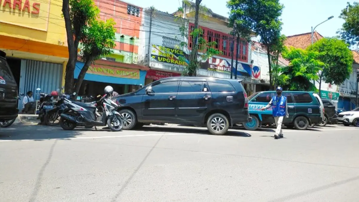 BELUM MAKSIMAL: Jukir mengawal pengendara di Jalan Panglima Sudirman Bangkalan, Selasa (5/5). (VIVIN AGUSTIN HARTONO/JPRM)