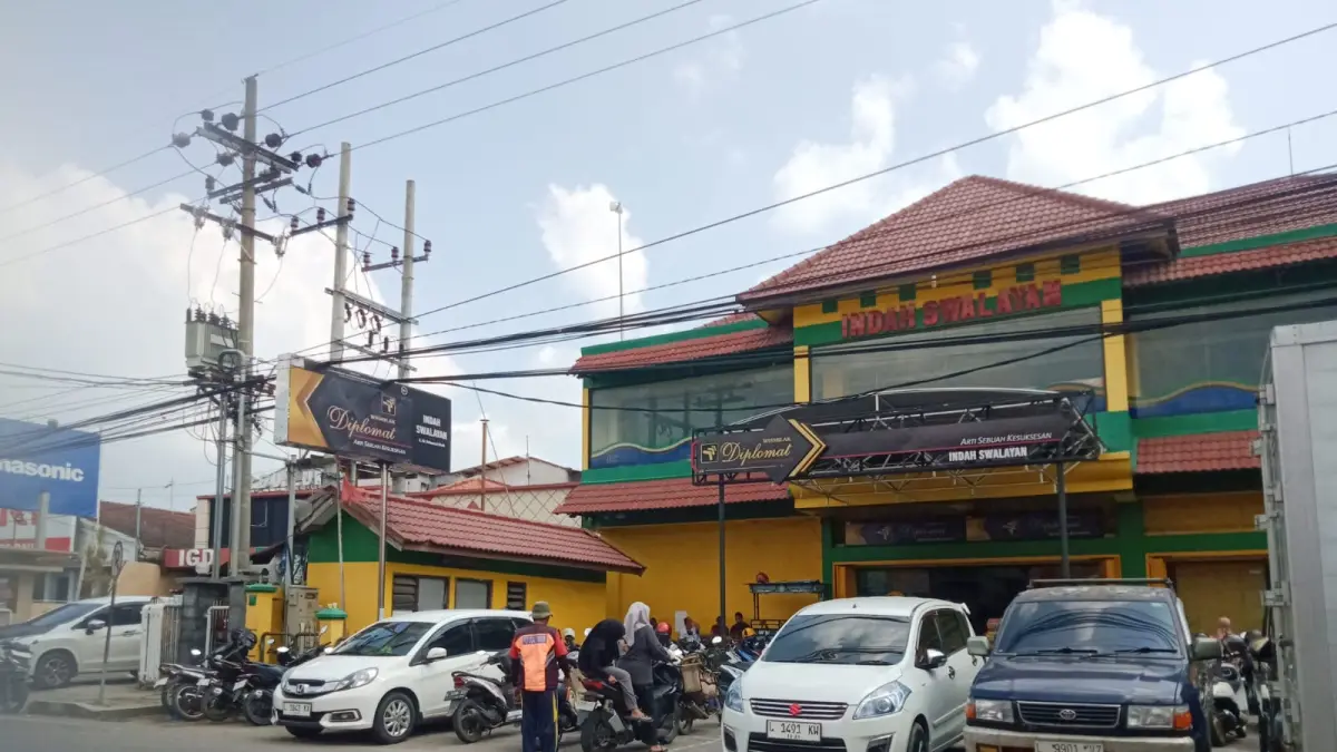 PADAT: Juru parkir yang sedang mengatur kendaraan yang hendak keluar dari toko swalayan di Jalan Moh. Kholil, Demangan, Bangkalan, Jumat (29/5)