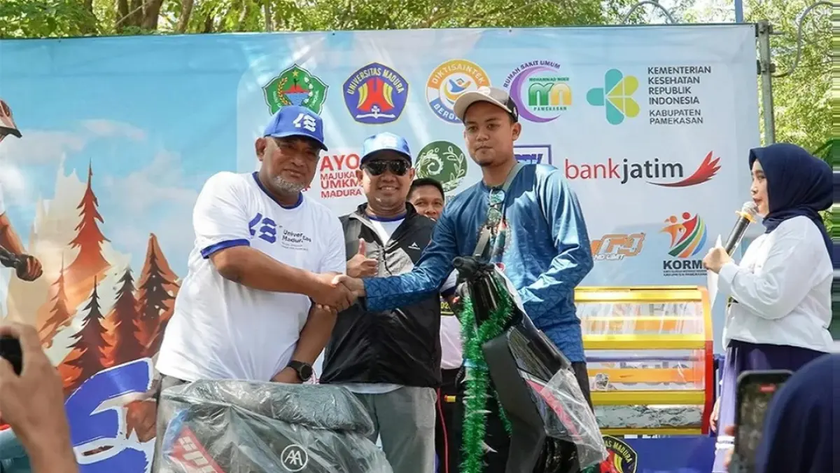 BAGI-BAGI HADIAH: Rektor Unira Dr. Drs. Ec. Gazali, M.M. sedang memberikan door prize kepada peserta fun bike yang beruntung, Minggu (31/5).