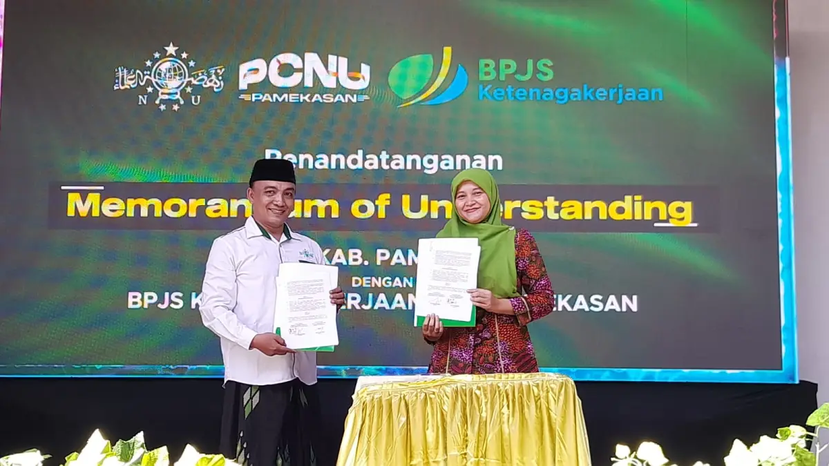 BERSINERGI: Kepala BPJS Ketenagakerjaan Pamekasan Anita Ardhiana (kanan) dan Ketua PCNU Pamekasan KH. Muchlis Nasir menunjukkan dokumen kerja sama pada momentum Muskercab I PCNU Pamekasan, di PP. Nurul Hidayah, Desa Lembung, Galis, Minggu (31/5). (M. KHOLIL RAMLI/JPRM)