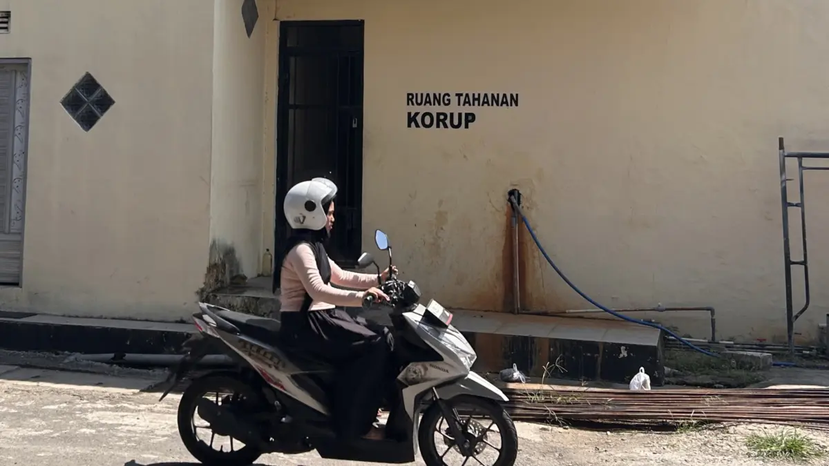 JERUJI BESI: Warga melintas di sekitar ruang tahanan Polres Sampang, Jumat (29/5). (UBAIDILLAHIR RA’IE/JPRM)