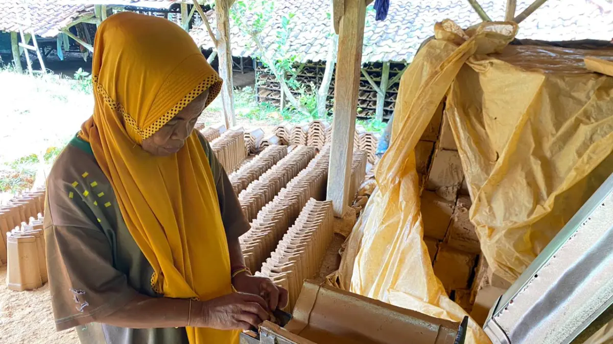 PRODUKTIF: Wardah menunjukkan proses pembuatan genting di Dusun Rakmerakan, Desa Tlambah, Kecamatan Karang Penang, Sampang, Sabtu (30/5). (AYU LATIFAH/JPRM)