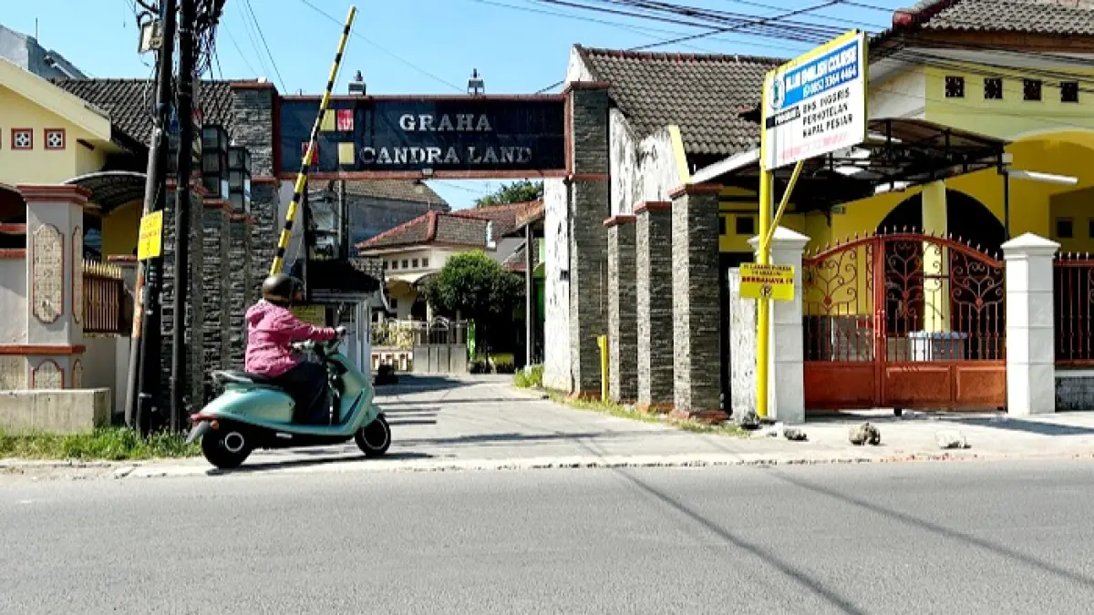 LENGANG: Pengendara sepeda motor melintas di depan gerbang Perumahan Graha Candra Land Bangkalan Senin (1/6). (VIVIN AGUSTIN HARTONO/JPRM)