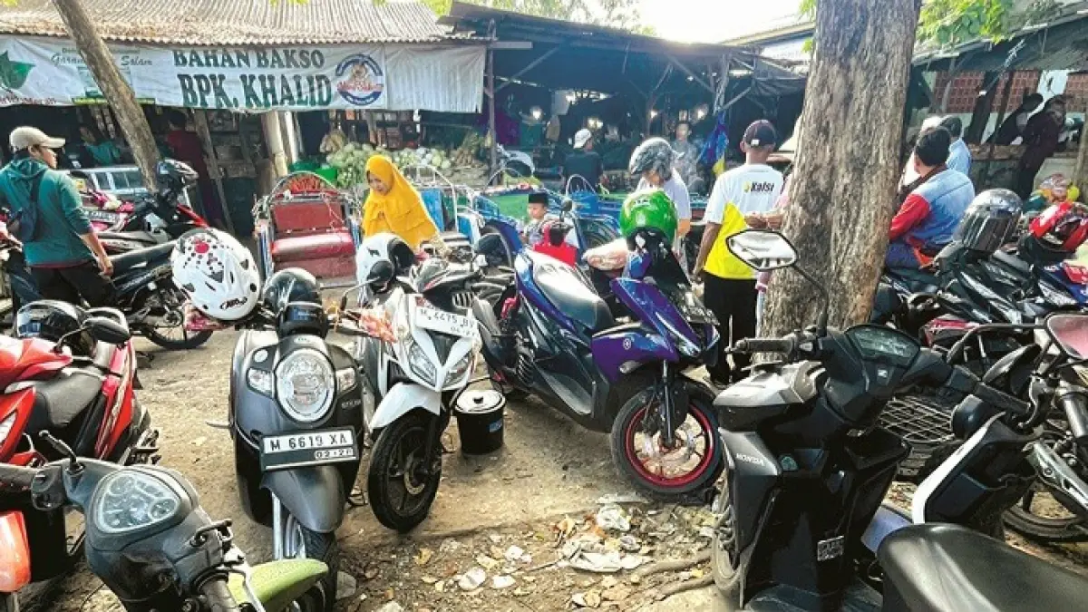 MELANGGAR: Oknum jukir liar menarik retribusi dari pengunjung Pasar Anom Sumenep Senin (1/6). (MOH. IQBAL/JPRM)