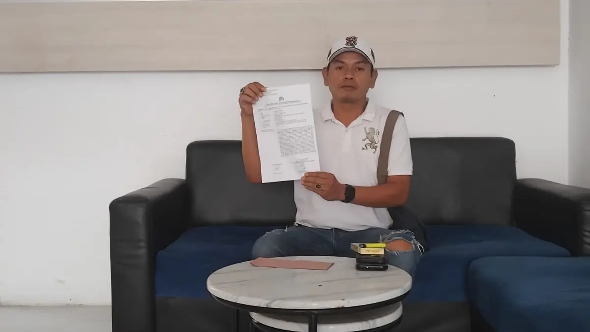 PROSES HUKUM: Pelapor Slamet Riyadi menunjukkan LP sebelum diperiksa penyelidik Polres Pamekasan, Sabtu (30/5).