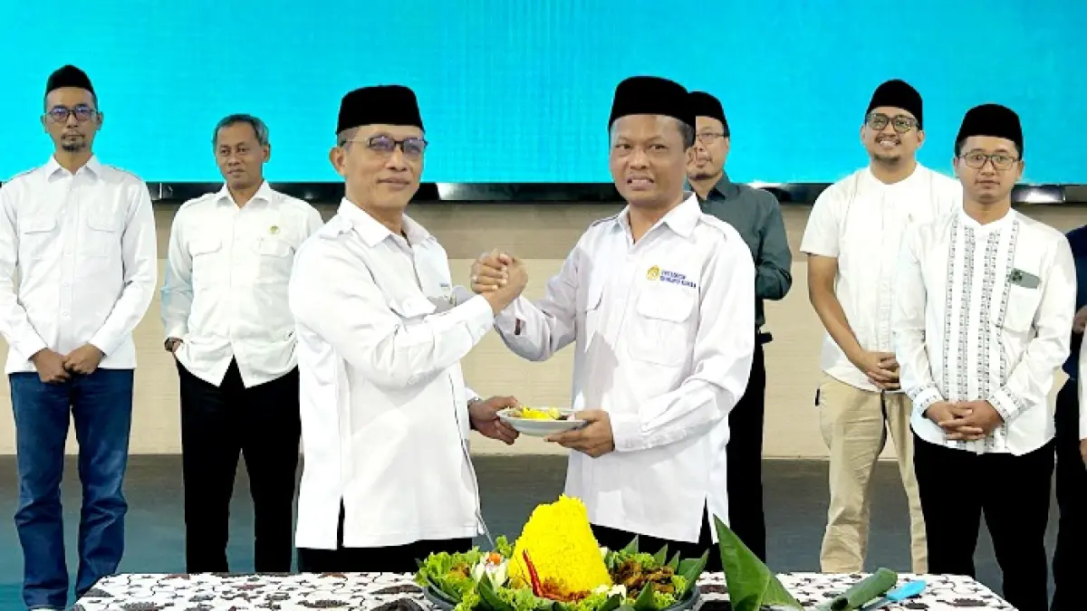SELAMAT: Rektor UTM Prof. Safi’ (kanan) menyerahkan potongan tumpeng kepada Dekan FKis UTM Abdur Rohman di gedung pertemuan Senin (8/6). (VIVIN AGUSTIN HARTONO/JPRM)