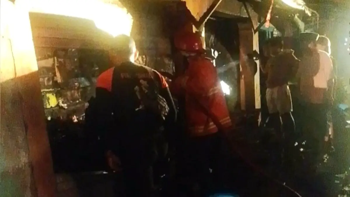 MEMBARA: Petugas pemadam kebakaran Satpol PP Bangkalan berusaha memadamkan kobaran api di Pasar Baru Kedungdung, Desa Patereman, Kecamatan Modung, Senin (8/6). (DAMKAR BANGKALAN UNTUK JPRM)