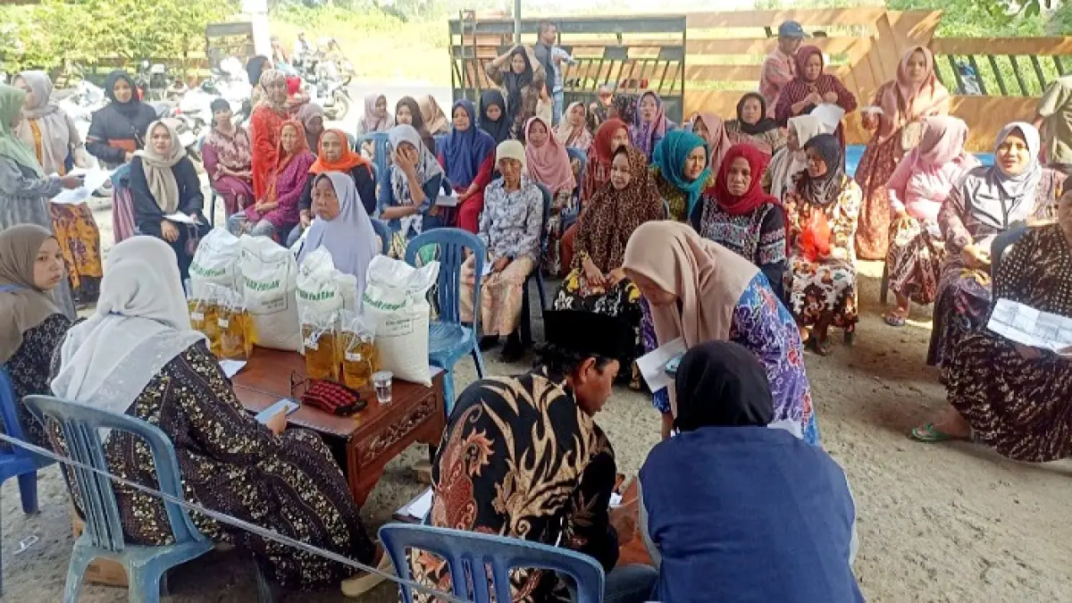 DIGANTI: Petugas menyalurkan bantuan pangan (banpang) kepada masyarakat di Desa Petrah, Kecamatan Tanah Merah Selasa (9/6). (AHMAD ROFI’I UNTUK JPRM)