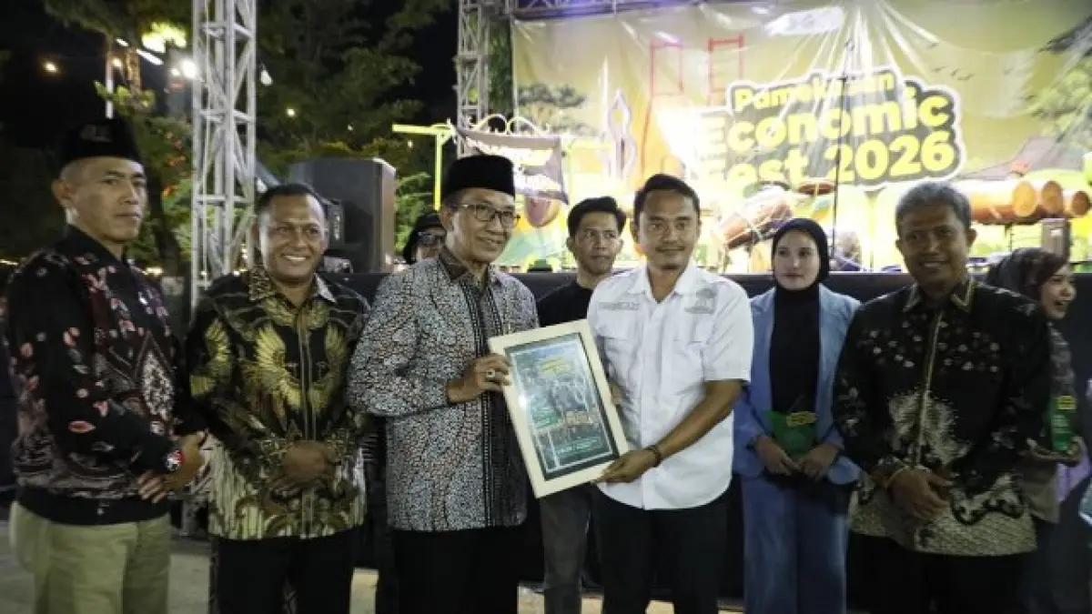 EKONOMI TUMBUH: Bupati Pamekasan KH Kholilurrahman memberikan piagam penyelenggaraan Pamekasan Economic Fest 2026 di Monumen Arek Lancor, Selasa (9/6) malam. (PROKOPIM PAMEKASAN UNTUK JPRM)