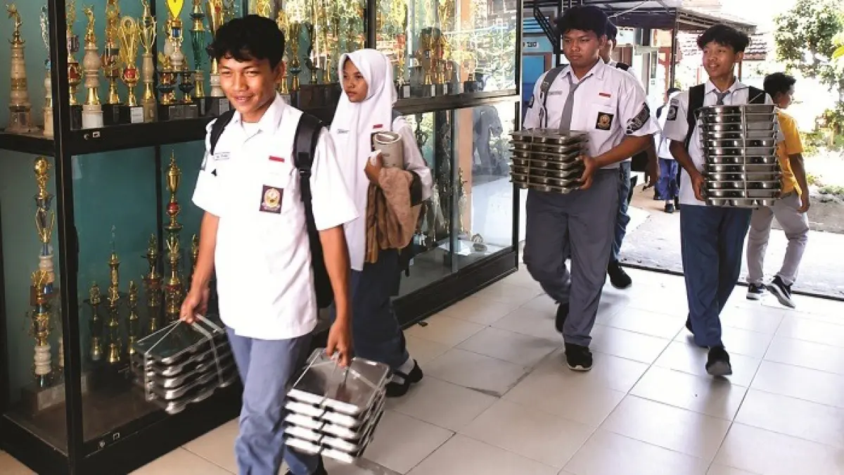 PENERIMA MANFAAT: Siswa SMAN 2 Pamekasan membawa ompreng MBG, Rabu (10/6). (M. KHOLIL RAMLI/JPRM)