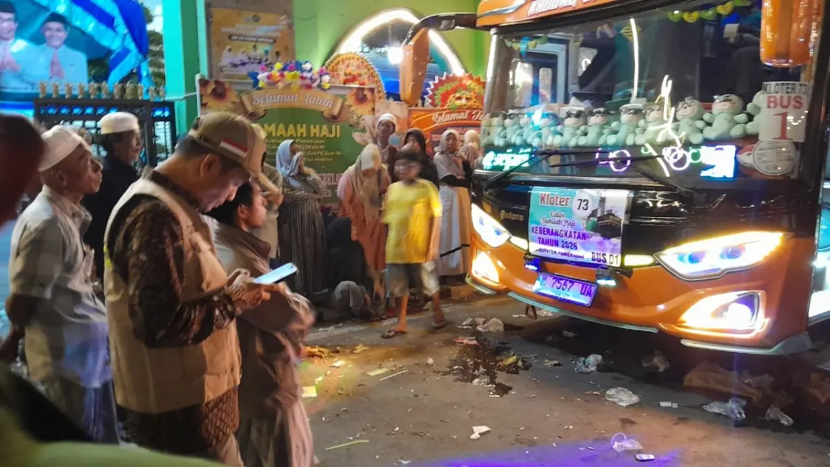 SIBUK: Kepala KHU Pamekasan, Abdul Halim (bertopi) memantau pemberangkatan jamaah haji ke tanah suci, Minggu (10/5).