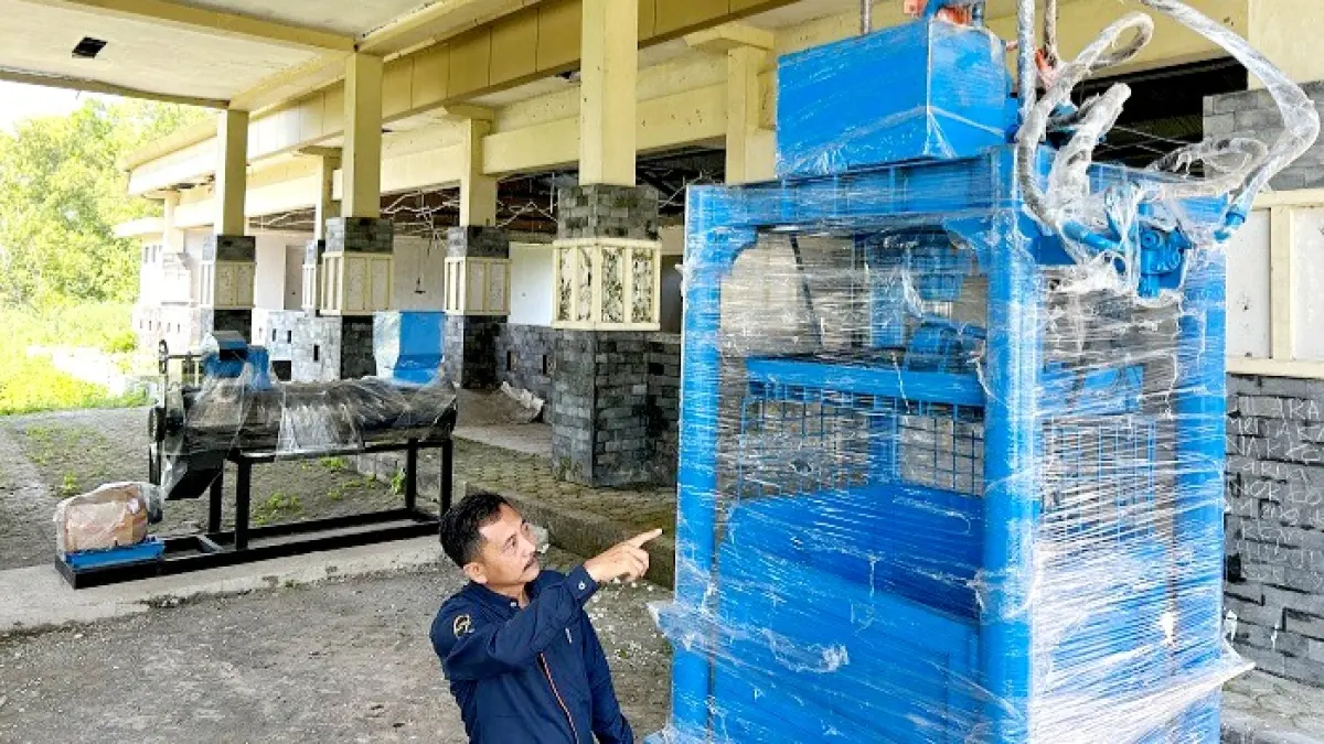 SIAP DIOPERASIKAN: Pelaksana pengadaan mesin Rustamadji menunjukkan mesin pengolah sampah di TPST Desa Masaran, Kecamatan Tragah, Selasa (16/6). (VIVIN AGUSTIN HARTONO/JPRM)
