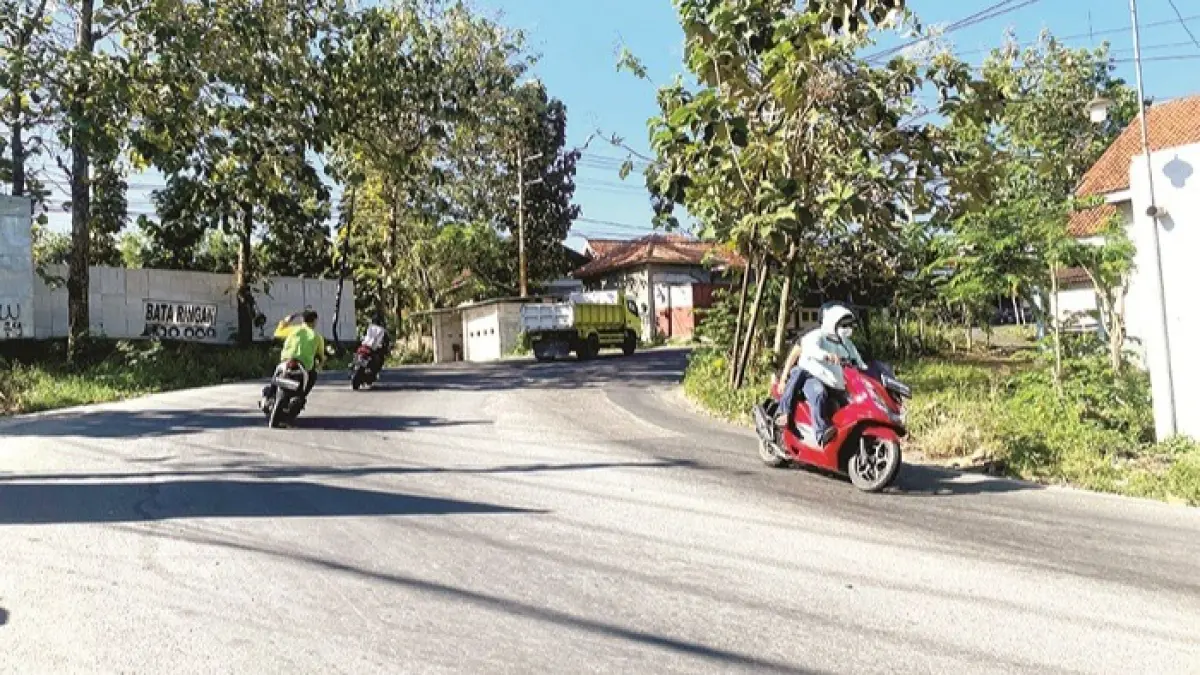 TERIK: Warga melintas di sekitar Jalan Raya Larangan Badung, Kecamatan Palengaan, Pamekasan, Selasa (16/6). (MOH. IQBAL AFGANI/JPRM)