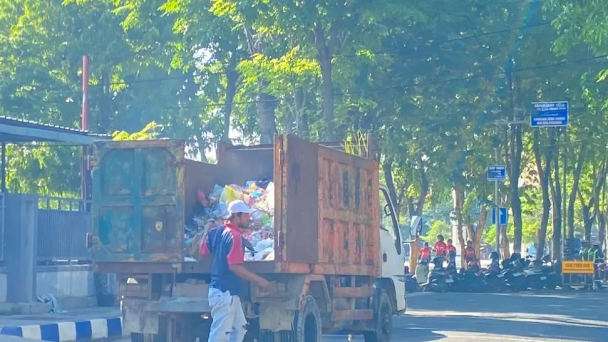 TERTIB: Pemuda sedang membuang sampah di Alun-Alun Trunojoyo, Sampang, Senin (15/6). (AYU LATIFAH/JPRM)