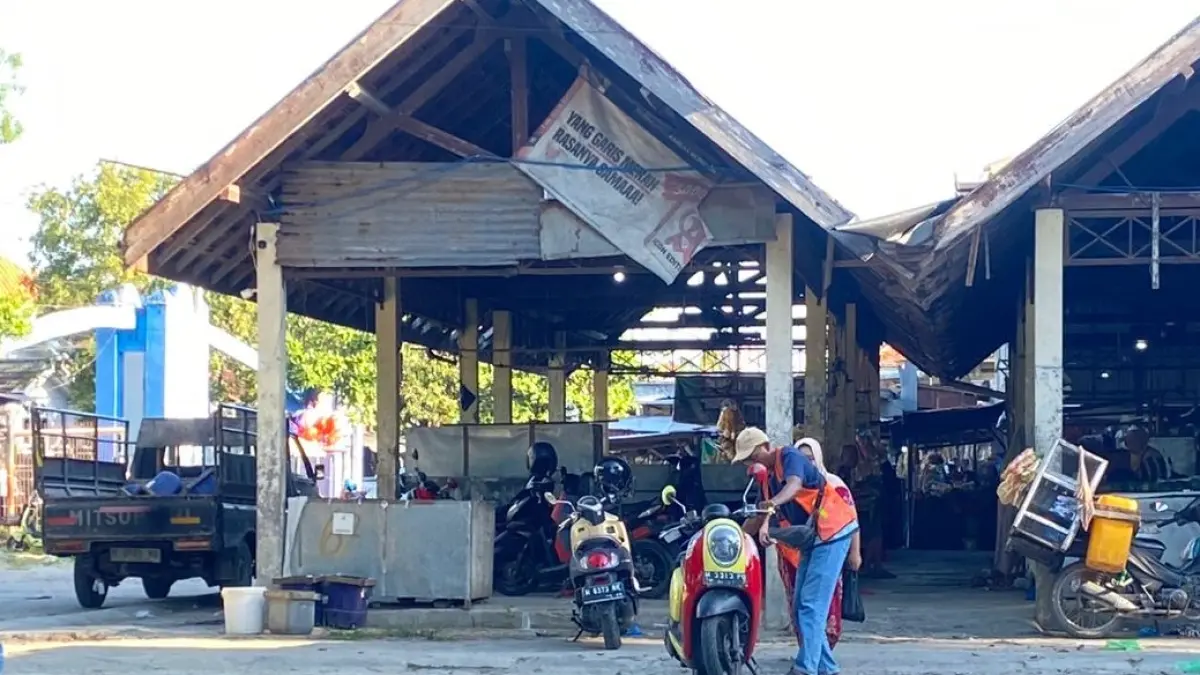 SUMBER PANDAPATAN: Jukir memarkir kendaraan bermotor pengunjung Pasar Sore Baru, Sampang, Rabu (17/6). (AYU LATIFAH/JPRM)