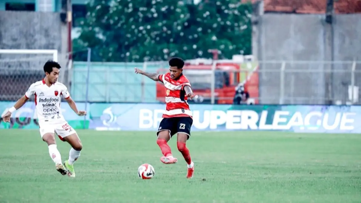 MEMBANGUN SERANGAN: Pemain MU Gio Numberi berusaha melewati pemain Bali United saat bertanding di SGB, Selasa (5/5). (MADURA UNITED UNTUK JPRM)