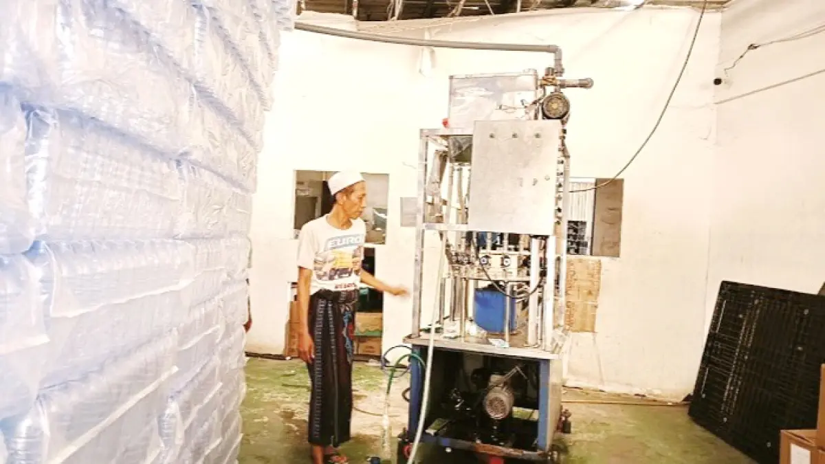 KECEWA: Pemilik usaha air mineral di Desa Parseh, Kecamatan Socah, menunjukkan mesin kompresor yang rusak akibat pemadaman listrik di Bangkalan, Sabtu (20/6). (ZEINAL ABIDIN/JPRM)