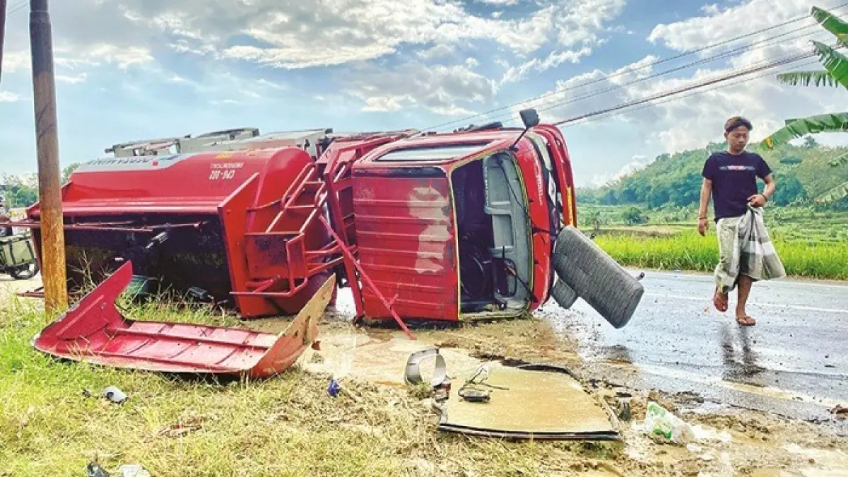 HATI-HATI: Warga berada di sekitar TKP kecelakaan truk Pertamina di Jalan Raya Pakong–Waru, Kecamatan Waru, Pamekasan, Selasa (23/6). (MOH. IQBAL AFGANI/JPRM)