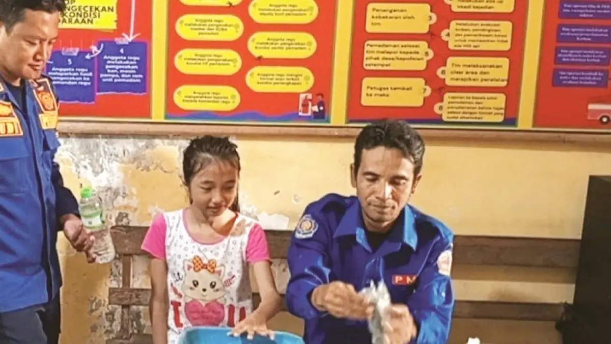 PENUH PERJUANGAN: Petugas damkar saat mengevakuasi cincin dari tangan Raisha di kantor Satpol PP Bangkalan kemarin. (DAMKAR BANGKALAN UNTUK JPRM)