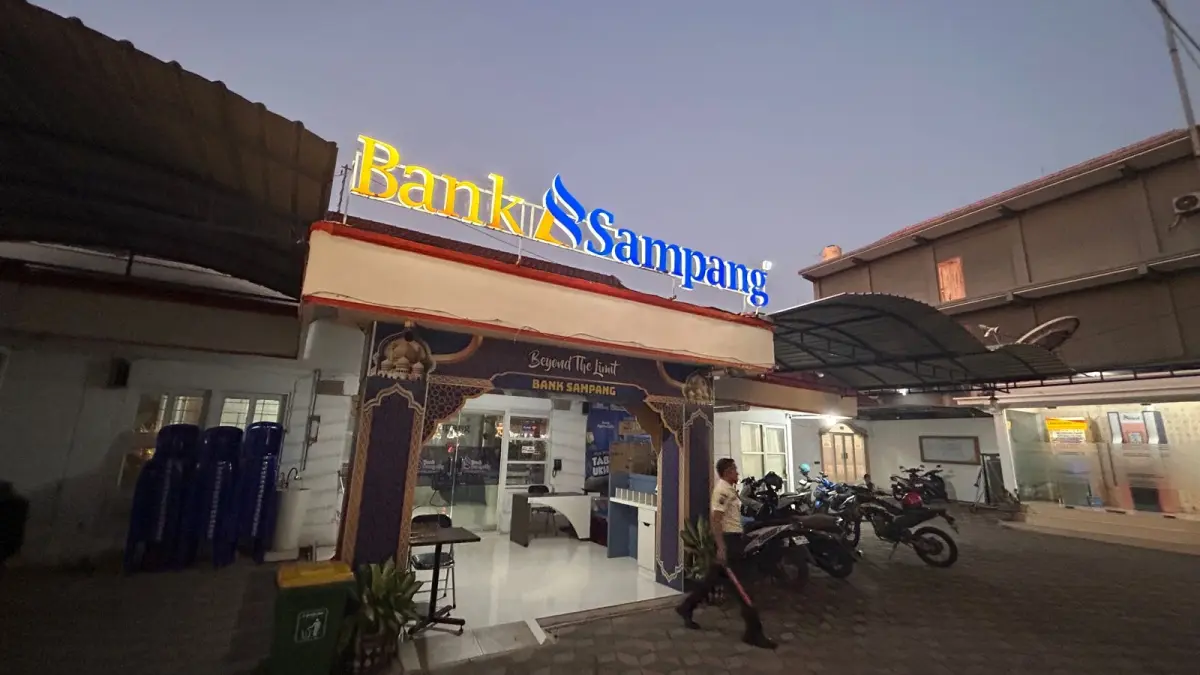 BERTUGAS: Sekuriti Bank Sampang sedang bertugas di kantornya yang terletak di Jalan Wachid Hasyim Sampang, Jumat (26/6).