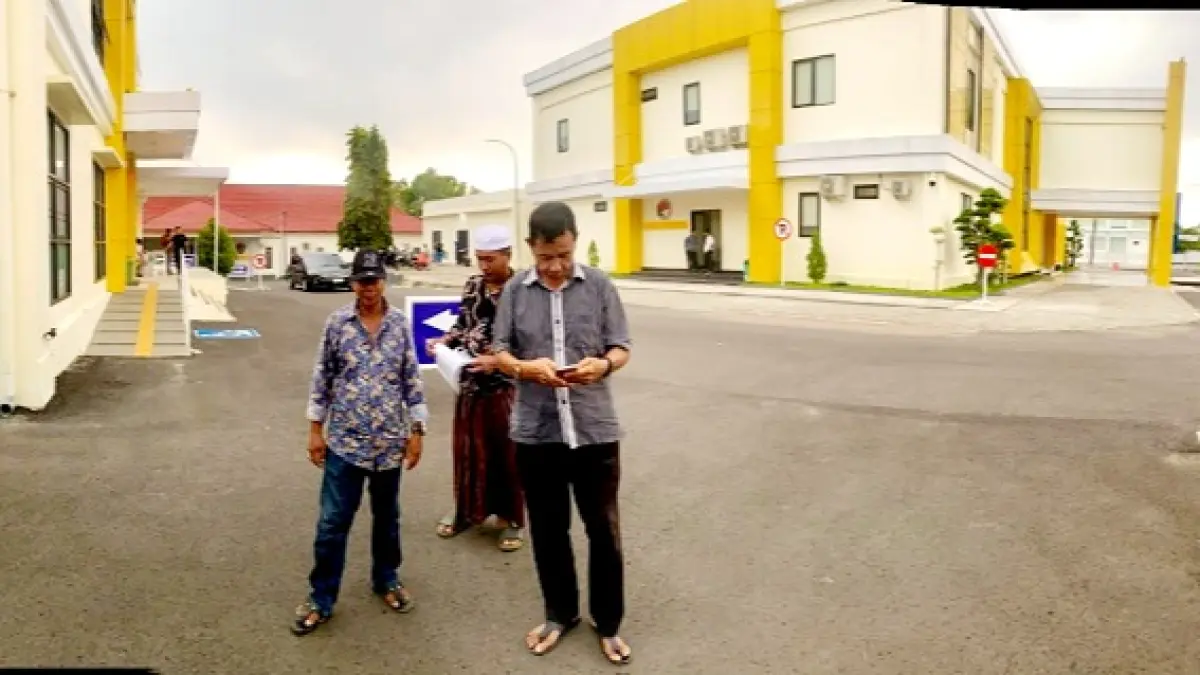 CARI KEPASTIAN: Pelapor kasus perusakan lahan proyek dinas PUPR berjalan menuju parkiran motor, November 2025. (DOK. JPRM)