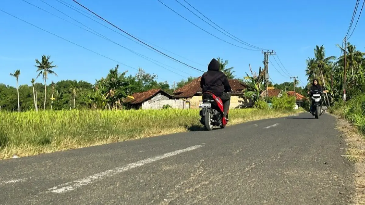 RETAK: Pengendara melintas di ruas jalan kabupaten di Desa Giring, Kecamatan Manding, Sumenep, Minggu (28/6). (MOH. IQBAL/JPRM)