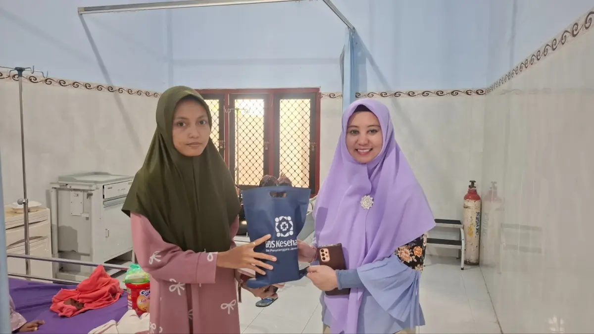 TALI ASIH: Kepala BPJS Kesehatan Pamekasan memberikan bungkusan kepada keluarga pasien.