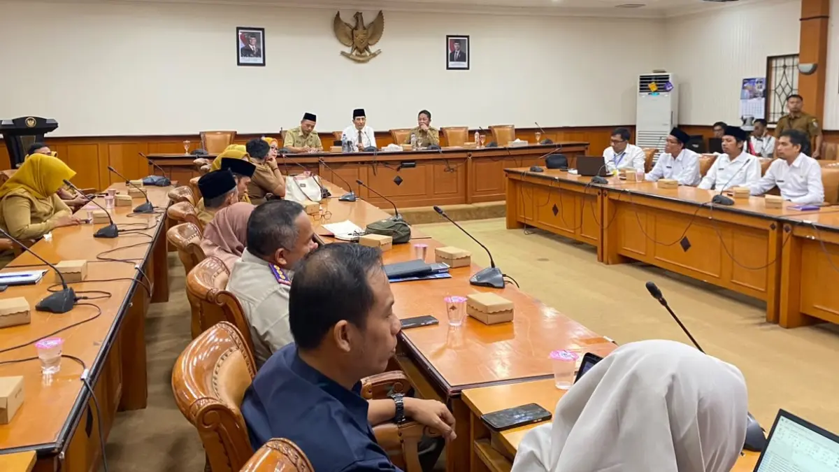 FOKUS: Sekkab Yuliadi Setiawan (kemeja putih), Kepala Dinsos PPPA Sampang M. Anwari Abdullah (kanan) didampingi Asisten Administrasi Umum Setkab Sampang Edi Subianto (kopiah hitam) saat rapat pleno penetapan siswa SR di aula mini pemkab, Senin (29/6). (AYU LATIFAH/JPRM)