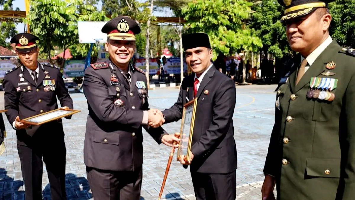 DIAPRESIASI: Bupati Bangkalan Lukman Hakim menerima penghargaan dari Kapolres AKBP Wibowo Rabu (1/7). (PROKOPIM UNTUK JPRM)