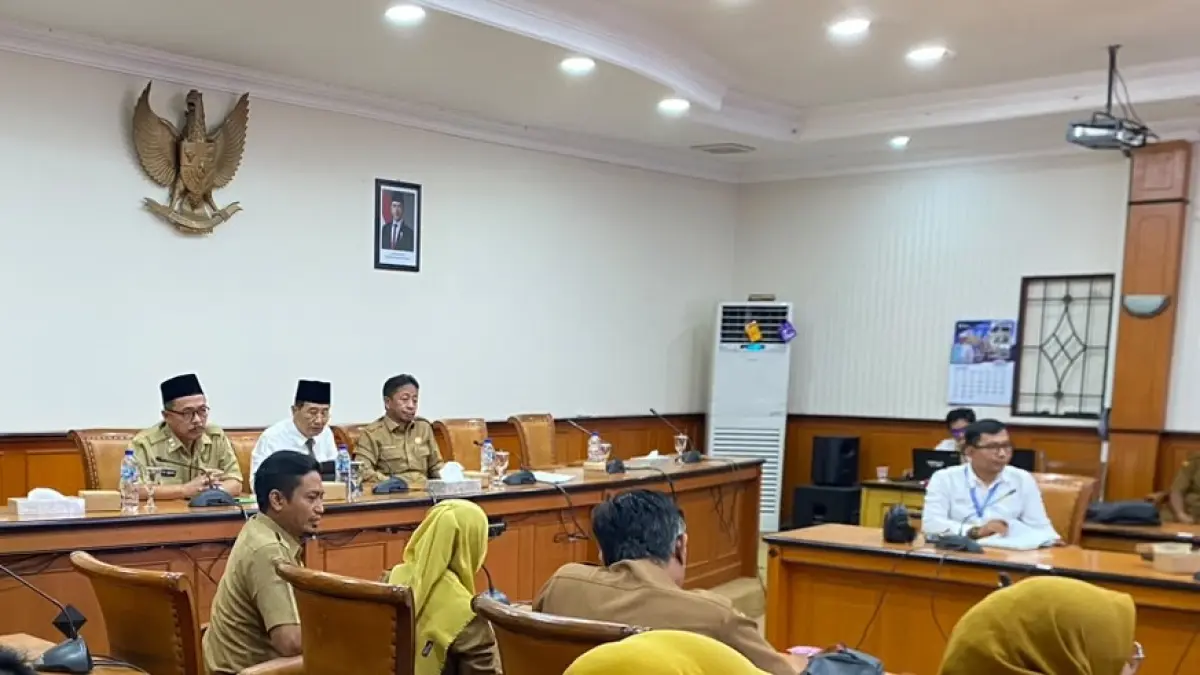 DISKUSI: Sekkab Yuliadi Setiawan (kemeja putih), Kepala Dinsos PPPA Sampang M. Anwari Abdullah (kanan) didampingi Asisten Administrasi Umum Setkab Sampang Edi Subianto (peci hitam) rapat pleno penetapan siswa SR di aula mini pemkab, Senin (29/6). (AYU LATIFAH/JPRM)