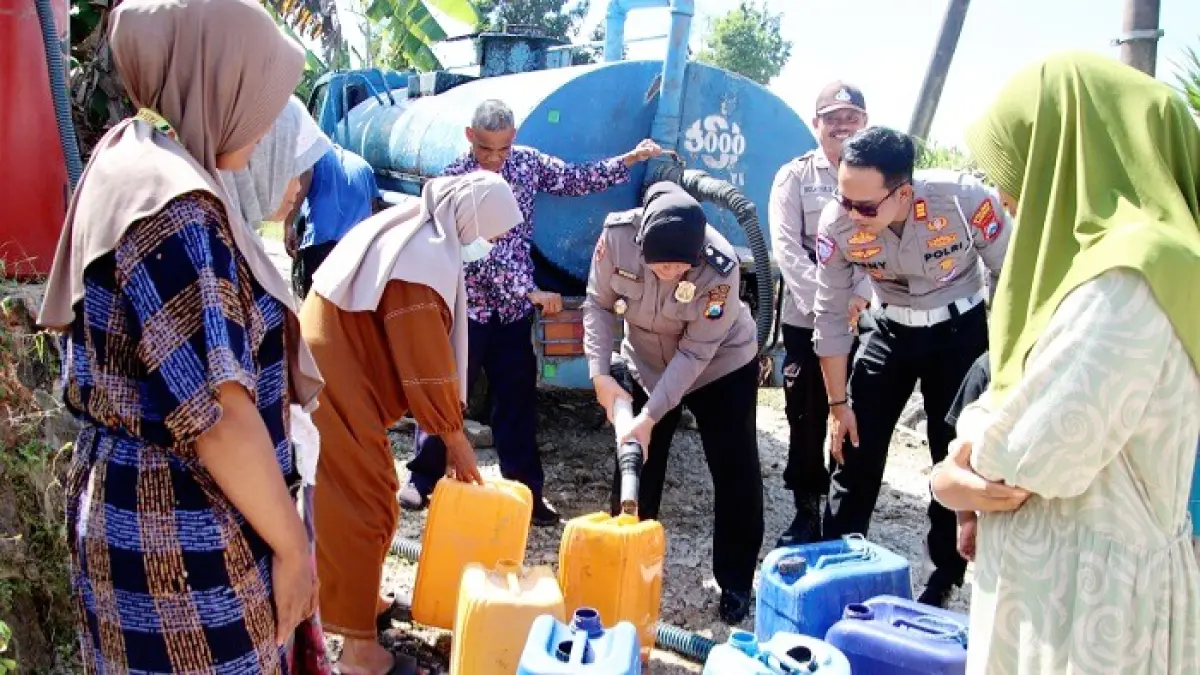 KEBUTUHAN UTAMA: Anggota Polri menyalurkan air bersih di wilayah Kecamatan Batuputih, Sumenep, Jumat (19/6). (POLRES UNTUK JPRM)