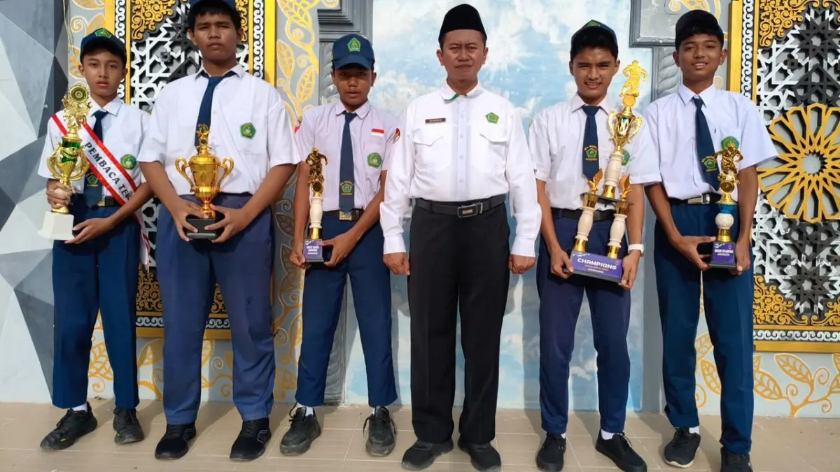 MEMBANGGAKAN: Kepala MTsN 2 Sumenep Hairuddin berfoto bersama siswa berprestasi di sekolahnya.